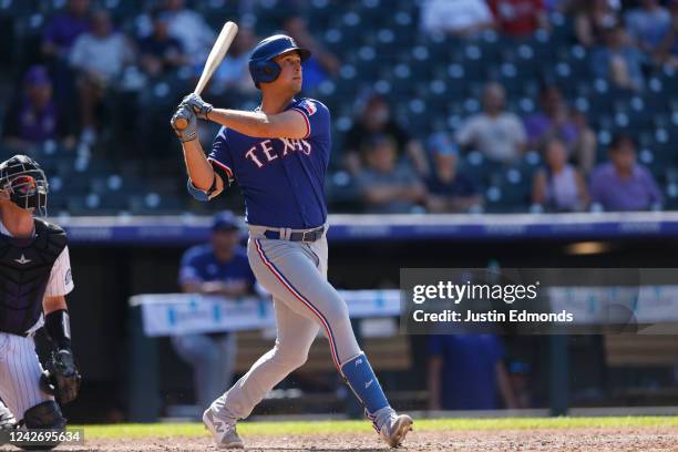 Nathaniel Lowe of the Texas Rangers watches his three run home run in the eighth inning as catcher Brian Serven of the Colorado Rockies watches the...