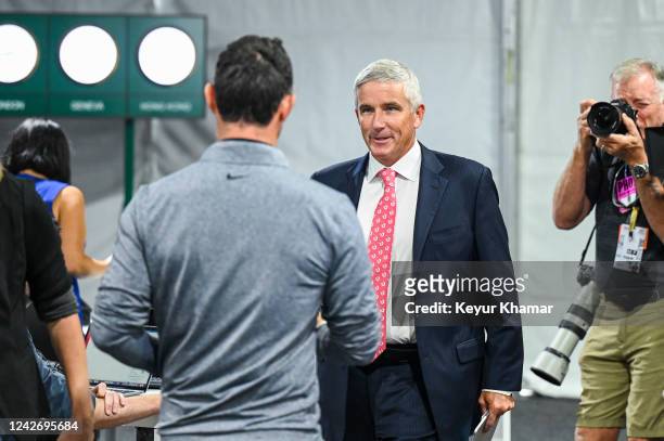 Commissioner Jay Monahan smiles as he greets Rory McIlroy of Northern Ireland at a press conference prior to the TOUR Championship, the third and...