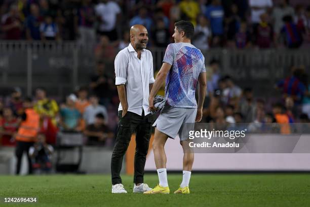 Manchester City's Spanish manager Pep Guardiola speaks with Barcelona's Polish forward Robert Lewandowski at the end of the friendly football match...