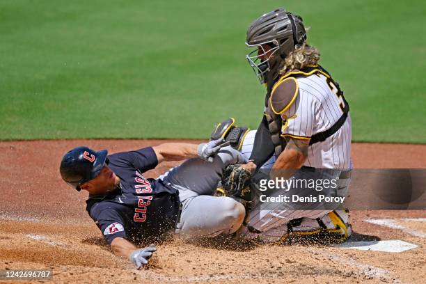 Myles Straw of the Cleveland Guardians is tagged out at the plate by Jorge Alfaro of the San Diego Padres during the fourth inning of a baseball game...
