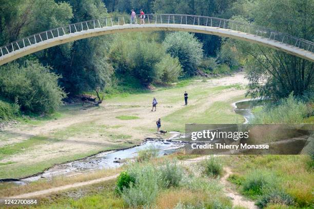 People walk under the bridge that pass over the dry steam 'Het Meertje' a tributary of the Waal river, the main distributary branch of the river...