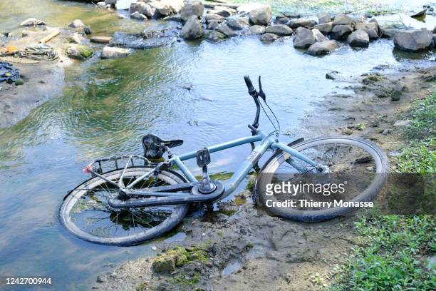 An abandoned bicycle emerges from the river 'Het Meertje', a tributary of the Waal river, the main distributary branch of the river Rhine on August...