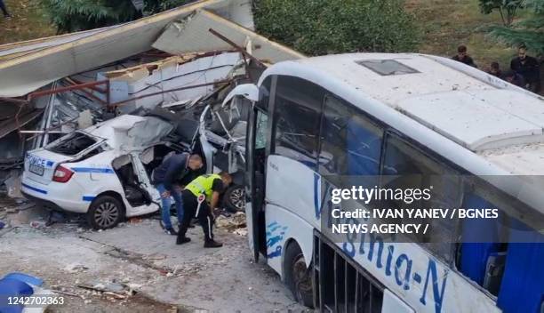 Officials work at the scene of a road accident, in which two police officers were killed after being hit by a bus transporting undocumented migrants,...