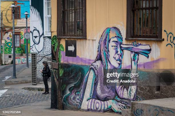 Woman walks past a street mural in Valparaiso, Chile, on August 17,2022. The Chilean city is an open-air gallery of graffiti and urban murals.