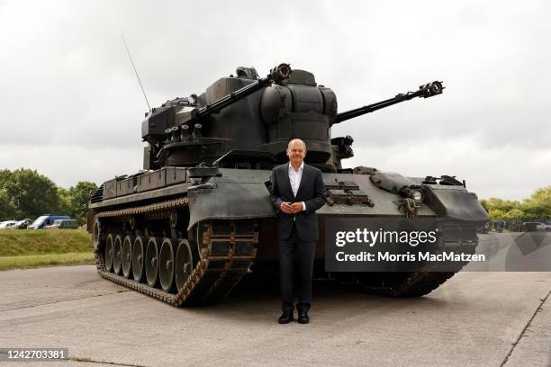 German Chancellor Olaf Scholz poses in front of an anti-aircraft gun tank Gepard during his visit a training facility of the arms-maker Krauss-Maffei...