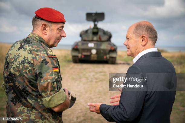 In this handout photo provided by the German Government Press Office , German Chancellor Olaf Scholz and Commander of the military training area,...