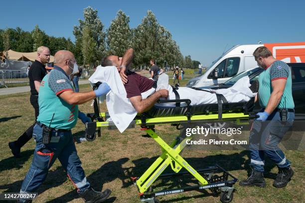 Refugee is transported to the hospital with an ambulance as hundreds of refugees sleep rough outside the refugee center on August 25, 2022 in Ter...