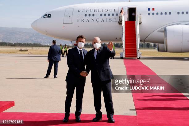 French President Emmanuel Macron is welcomed by Algeria's President Abdelmadjid Tebboune upon arrival at the airport in Algiers on August 25 at the...