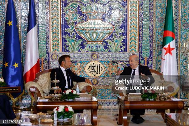 French President Emmanuel Macron and Algeria's President Abdelmadjid Tebboune attend a meeting at the VIP lounge of the airport in Algiers on August...