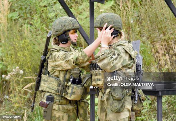 Female officers of the Russian Interior Ministry check their equipment as they attend the All-Russian competition "Alive forever" in shooting from...