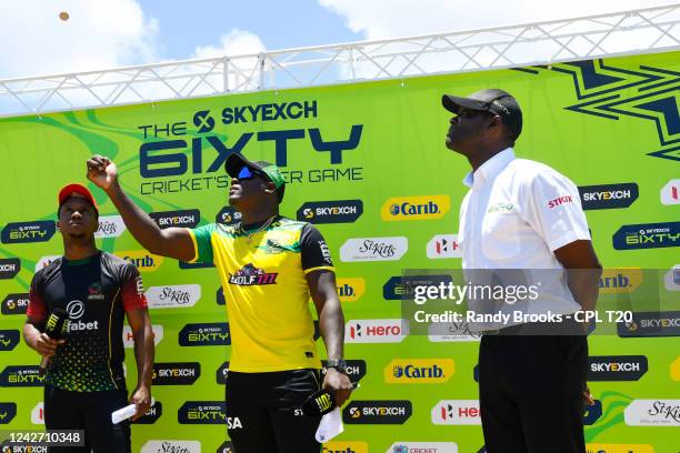 Rovman Powell of Jamaica Tallawahs toss the coin as Evin Lewis and match referee Reon King look on during the 2022 Hero Caribbean Premier League -...