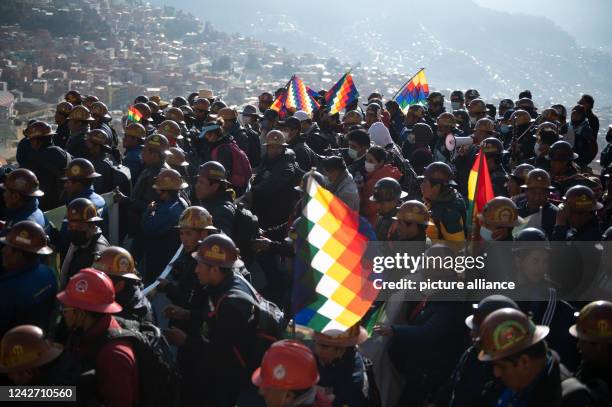 August 2022, Bolivia, La Paz: Supporters of President Arce's government march with flags and mining helmets during a rally in support of the...