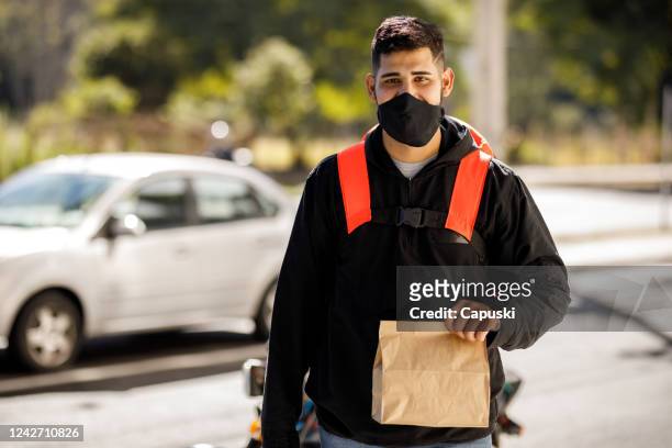 delivery man arriving on destination with package - motoboy - motoboy stock pictures, royalty-free photos & images