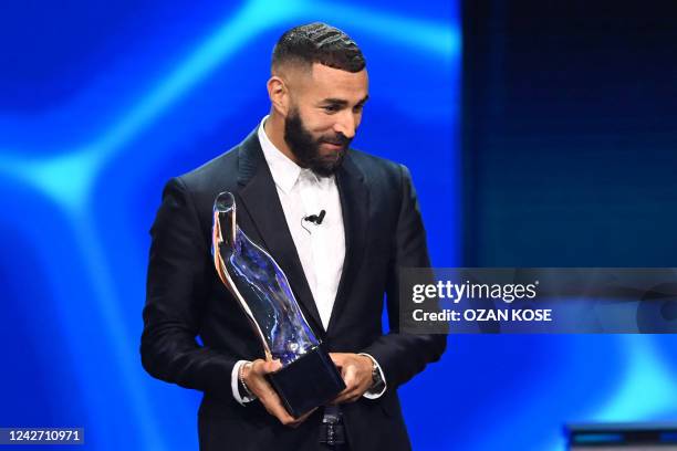Real Madrid's French forward Karim Benzema holds his men's best player of the year award for the 2021/2022 season on stage during the awarding...