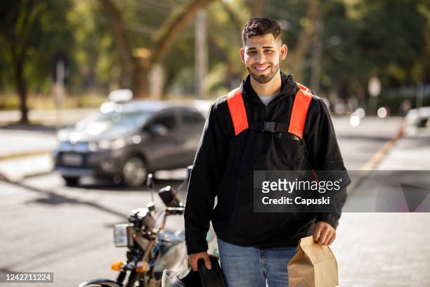 delivery man arriving on destination with package - motoboy - motoboy stock pictures, royalty-free photos & images