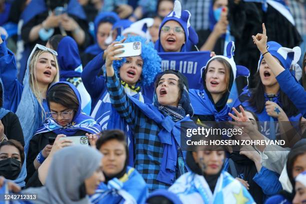 Iranian women fans of Esteghlal football club cheer during a match between Esteghlal and Mes Kerman at the Azadi stadium in the capital Tehran, on...