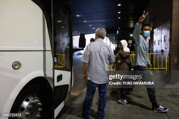 Migrant, who boarded a bus in Texas, gives a peace sign as they arrive at Port Authority Bus Terminal in New York City on August 25, 2022. - Since...