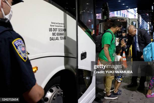 New York Immigrant Affairs Commissioner Manuel Castro high-fives a child as a group of migrants, who boarded a bus in Texas, arrive at Port Authority...