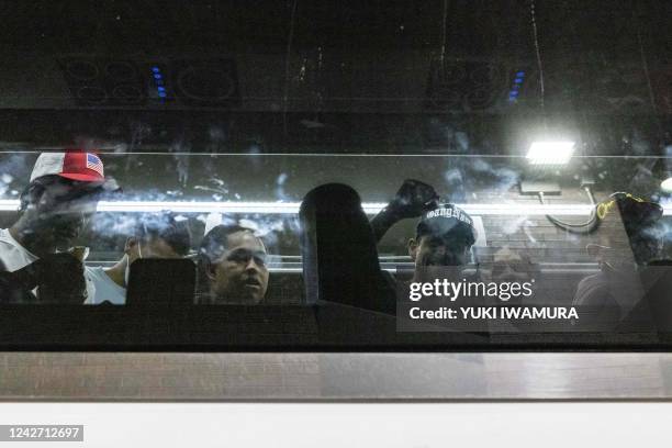 Group of migrants, who boarded a bus in Texas, are seen raising thier fist through the window as they arrive at Port Authority Bus Terminal in New...