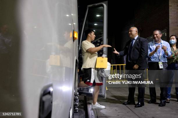 New York Immigrant Affairs Commissioner Manuel Castro shakes hands with a group of migrants, who boarded a bus in Texas, as they arrive at Port...