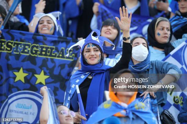 Iranian women fans of Esteghlal football club cheer during a match between Esteghlal and Mes Kerman at the Azadi stadium in the capital Tehran, on...