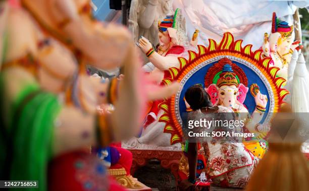 An artist works on an idol of the elephant-headed Hindu deity Ganesha ahead of the Ganesh Chaturthi festival in New Delhi. Ganesh Chaturthi is a...