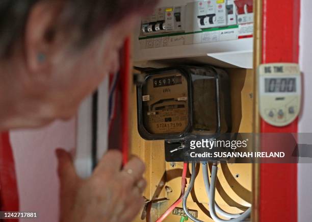 Energy customer Diane Skidmore examines her electricity meter in her flat on the south London estate where she lives, on August 25, 2022. -...
