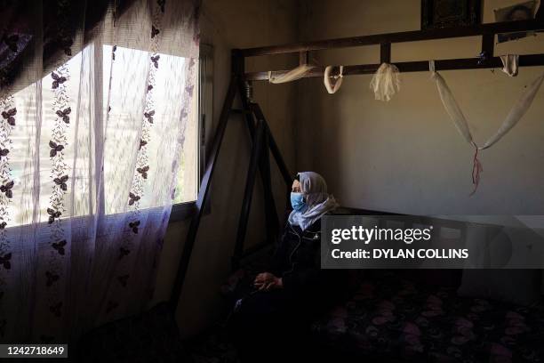 Syrian refugee 'Tuqqa' looks out through the window of her apartment in Lebanon's Bekaa Valley, on June 13, 2022. - Half a million people, mostly...