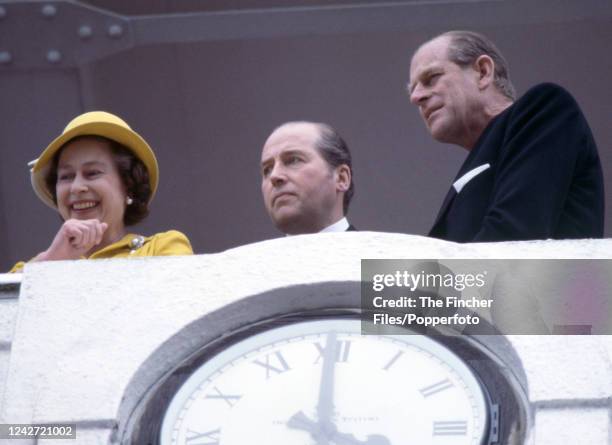 Queen Elizabeth II and Prince Philip with Henry Herbert, Lord Porchester watching from the balcony during the Epsom Derby at Epsom racecourse in...