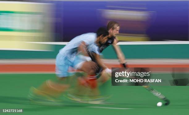 Blair Hilton of New Zealand and Singh Rupinder Pal of India compete for the ball during the Sultan Azlan Shah Cup men's field hockey tournament in...