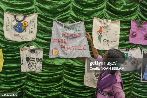 School child points to a cloth bag exhibited at an exhibition stall during a beach clean-up campaign organised by the government of Andhra Pradesh in...