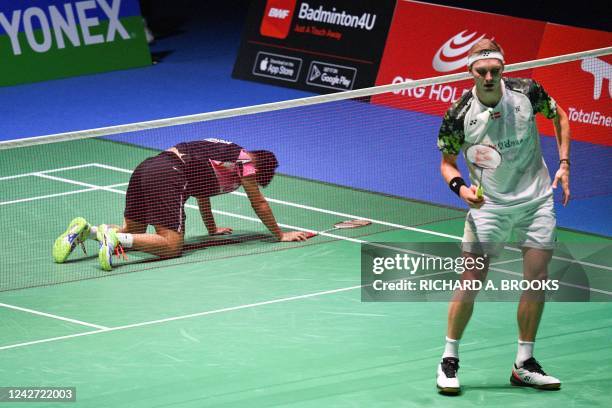 Viktor Axelsen of Denmark picks up the shuttlecock after opponent Anthony Sinisuka Ginting of Indonesia fell on the court during their men's singles...