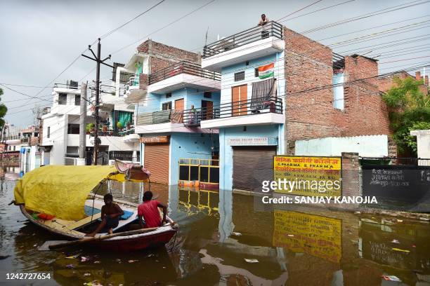 Residents look out from their home in a flooded residential area in Allahabad on August 26 following heavy monsoon rains that caused the overflowing...