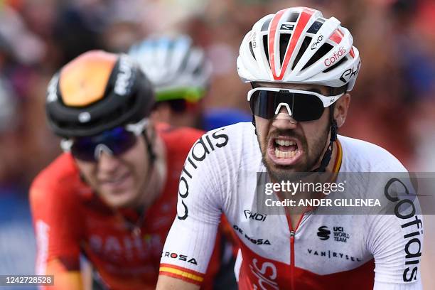 Team Cofidis' Spanish rider Jesus Herrada celebrates as he crosses the finish line in first place next to third placed Team Bahrain's British rider...