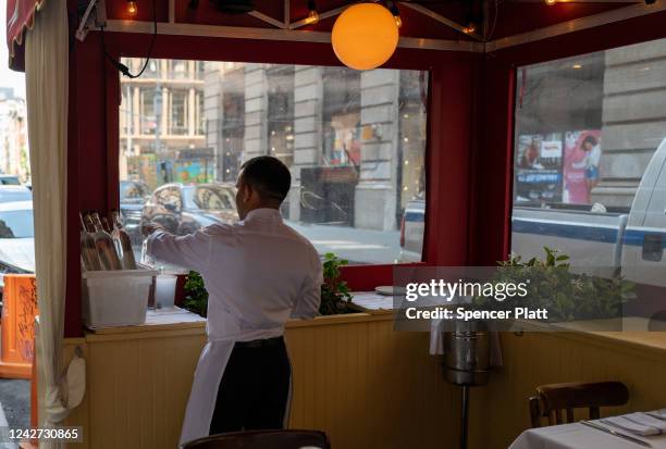 Waiter walks among tables at a New York City restaurant in a shopping district on August 26, 2022 in New York City. The Commerce Department announced...