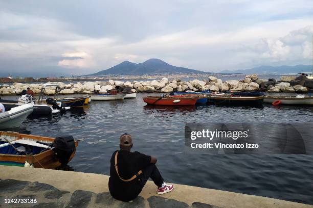 Man observes Vesuvius on the shores of the gulf of Naples.