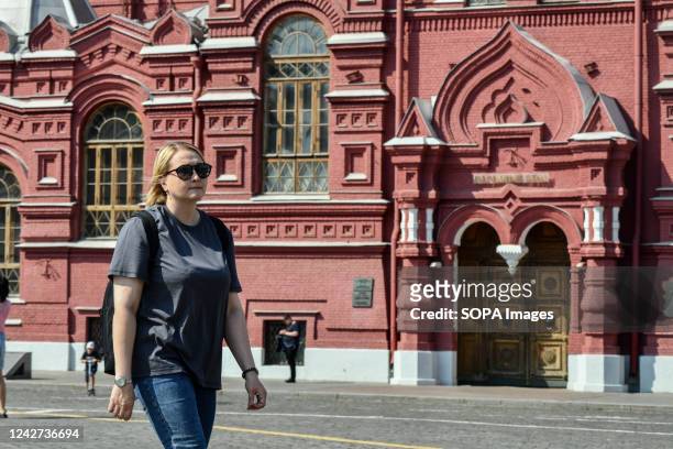 Woman walks along the Red Square in front of the Historical Museum.