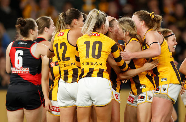 Sophie Locke of the Hawks celebrates the Hawks first goal with teammates during the 2022 S7 AFLW Round 01 match between the Essendon Bombers and the...