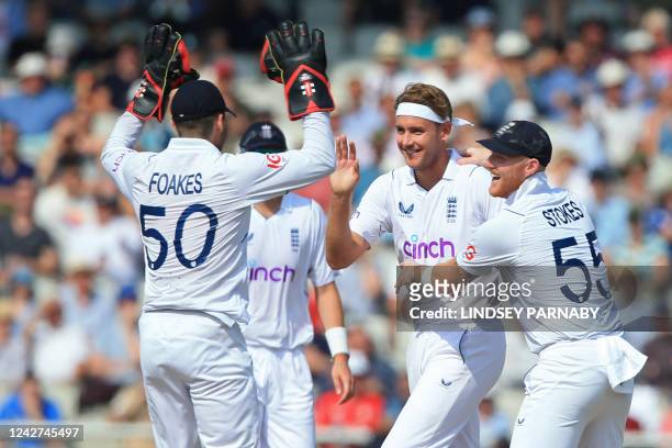 England's Stuart Broad celebrates with teammates after taking the wicket of South Africa's Aiden Markram on day 3 of the second Test match between...