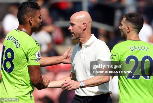 Manchester United's Dutch manager Erik ten Hag celebrates with Manchester United's Brazilian midfielder Casemiro and Manchester United's Portuguese...