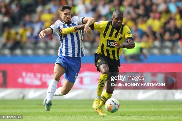 Hertha Berlin's German midfielder Suat Serdar and Dortmund's French forward Anthony Modeste vie for the ball during the German first division...