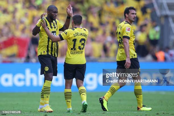 Dortmund's French forward Anthony Modeste celebrates scoring the opening goal with his teammates Dortmund's Portuguese defender Raphael Guerreiro and...