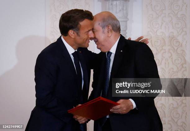 French President Emmanuel Macron and Algeria's President Abdelmadjid Tebboune attend a signing ceremony in the pavilion of honour at Algiers airport,...