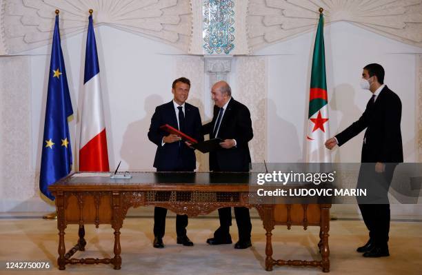 French President Emmanuel Macron and Algeria's President Abdelmadjid Tebboune attend a signing ceremony in the pavilion of honour at Algiers airport,...