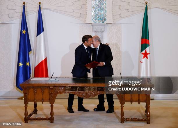 French President Emmanuel Macron and Algeria's President Abdelmadjid Tebboune attend a signing ceremony in the pavilion of honour at Algiers airport,...