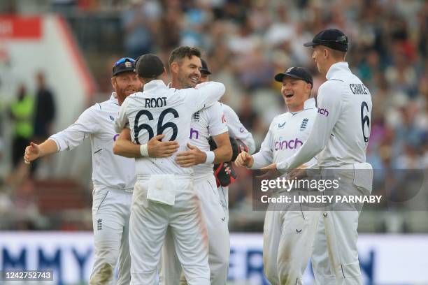 England's James Anderson celebrates with teammates after taking the wicket of South Africa's Kagiso Rabada on day 3 of the second Test match between...