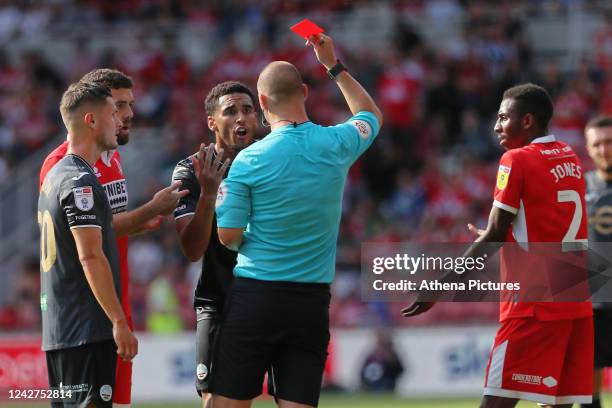 Referee Robert Madley shows a red card to Ben Cabango of Swansea City during the Sky Bet Championship match between Middlesbrough and Swansea City at...