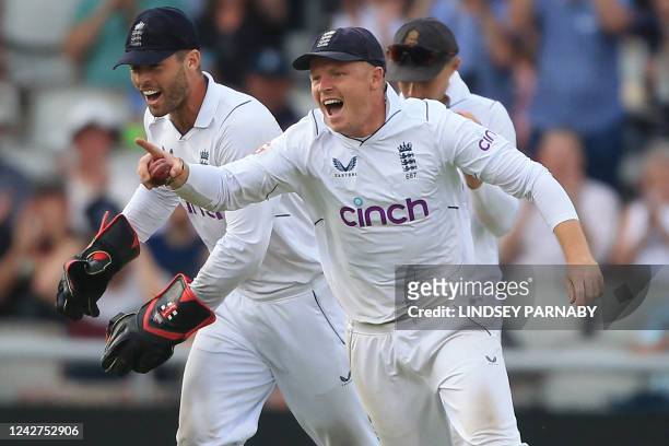 England's Ollie Pope celebrates after taking a catch to dismiss South Africa's Keshav Maharaj off the bowling of England's Ollie Robinson on day 3 of...