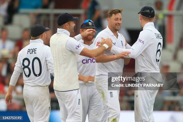 England's Ollie Robinson celebrates with teammates after taking the wicket of South Africa's Anrich Nortje on day 3 of the second Test match between...