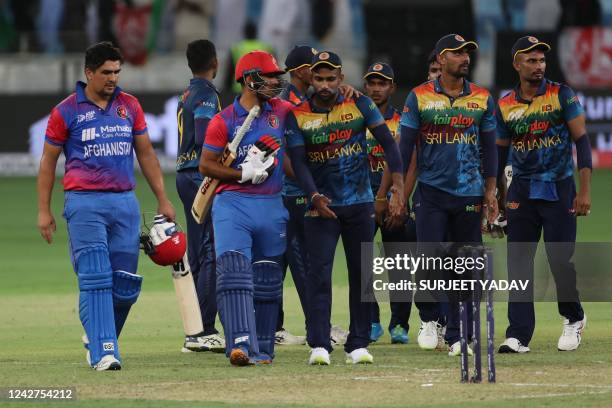 Afghanistan's Hazratullah Zazai and his teammate Najibullah Zadran leave the field at the end of the Asia Cup Twenty20 International cricket Group B...